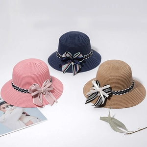Detailed texture of straw sun hats with ribbon bows and pearls in three pastel colors