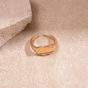 Detail of a gold adjustable signet ring with a polished oval mirror surface on stone