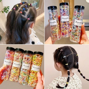 Kids colorful hair ties set in a clear round tube shown on hair and in packaging