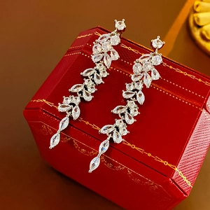 Macro detail of silver drop earrings with marquise cubic zirconia on a red gift box