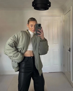 Mirror selfie showing olive green bomber jacket with white crop top and leather pants