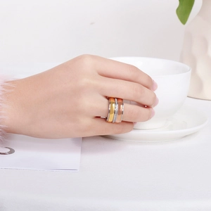 Close-up of triple band stackable ring in gold, rose gold and silver with zircon accents