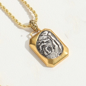 Detailed macro view of a dual-tone geometric pendant necklace with mythical engraving