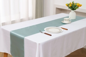 Detailed texture of teal satin table runner with elegant silk sheen in home setting