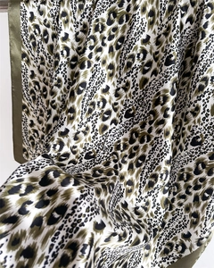 Detailed macro view of leopard print silk scarf texture with olive green border finish
