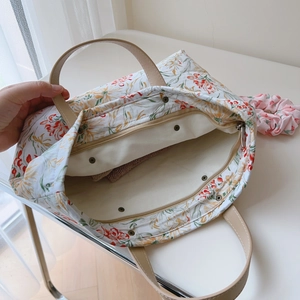 Vue macro de l'intérieur du tote bag fleuri avec compartiments et poche zippée pratique