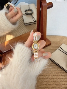 Detail of the vintage oval pearl watch with a mother-of-pearl dial and golden frame
