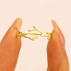 Detailed macro view of a golden branch ring showcasing thin texture and polished metal finish