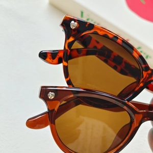 Close-up of tortoise shell sunglasses frames with silver heart rivets and cat eye shape