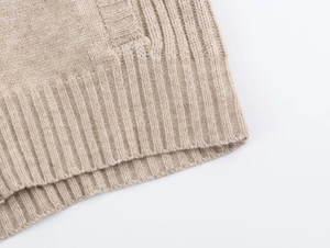Detailed close-up of beige ribbed knit texture and soft fabric finish on the garment