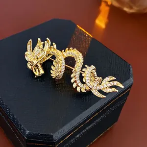 Exquisite gold-plated dragon brooch with white crystals on a black jewelry box