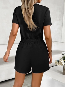 Rear view of a solid black short-sleeved women's romper with an elastic waist detail
