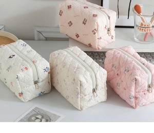 Close-up of quilted makeup bags with cute cartoon prints and metal zipper detail