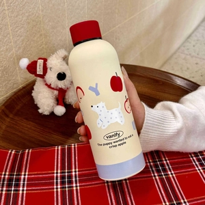 Detail of hand-held cream vacuum flask with red lid and cartoon puppy apple prints