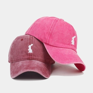 Close-up of vintage washed cotton baseball caps with white rabbit silhouette embroidery