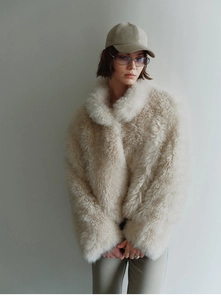 Detail of soft cream faux fox fur vest showing plush texture and high neck collar design