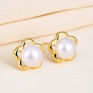 Elegant S925 silver flower pearl stud earrings with gold finish on ivory satin background