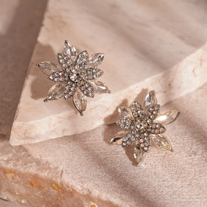 Macro detail of silver snowflake flower stud earrings with sparkling clear crystals