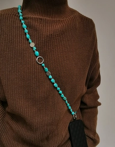 Detail of turquoise beaded phone strap with silver clasp and irregular shaped stones