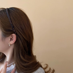 Detail view of retro leopard print headband and pearl earrings on female model