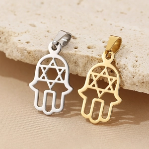 Macro shot of 18K gold and silver Hamsa palm pendants with Star of David on stone