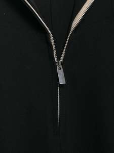 Detailaufnahme des polierten silbernen Metallreißverschlusses an der schwarzen Damenhose