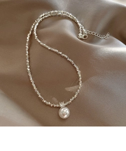 Detailed macro view of silver beaded pearl necklace with adjustable lobster clasp closure