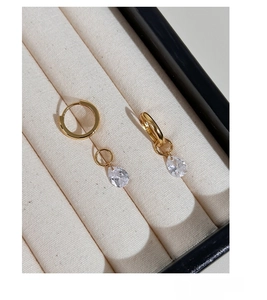 Detailed close-up of golden S925 silver hoop earrings with water drop zircon pendants