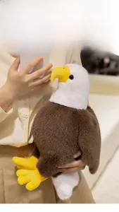 Detailed view of a soft bald eagle plush toy being held in a cozy home setting