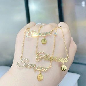 Detail of three gold zodiac necklaces featuring Cancer, Taurus and Scorpio letter pendants