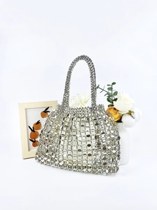 Detail of silver hollow metal woven handbag with sparkling round sequins on white background