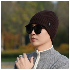 Close-up of a brown ribbed knit beanie with a square woven patch label for winter wear