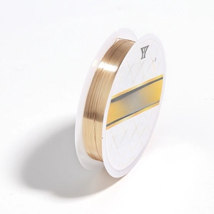 Detail view of 0.3mm gold plated jewelry copper wire on a professional white spool