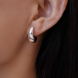 Close-up of a silver waterdrop metal stud earring with mirror finish on model