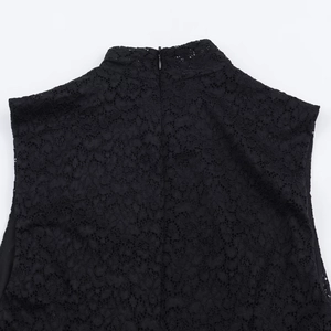 Detail of black lace dress showing intricate floral embroidery and invisible back zipper