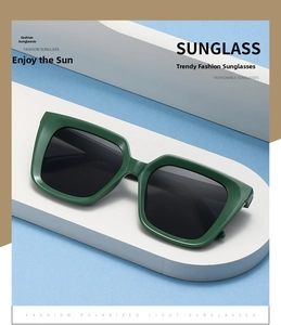 Close-up of green square frame sunglasses with dark polarized lenses on display
