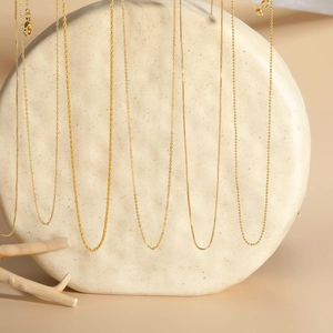 Detail shot of 18K gold plated copper necklaces showing different chain styles and textures