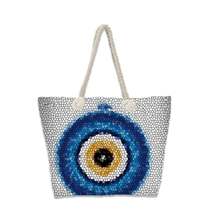 Detail of white canvas beach tote with mosaic evil eye pattern and rope handles
