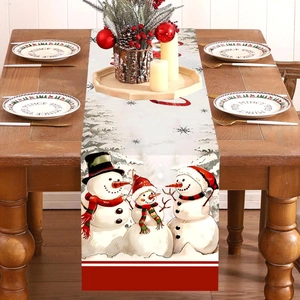 Christmas snowman table runner on a wooden table with festive candles and decor