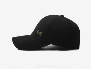Detail of black cotton baseball cap with a bronze metallic badge and parallel stitches