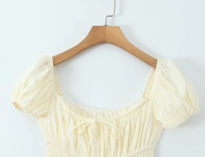 Detailansicht der Puffärmel und Kordelzugbindung an diesem hellgelben Kleid im französischen Stil