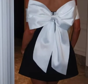 Vue détaillée du dos d'une robe de soirée noire avec un grand nœud en satin blanc