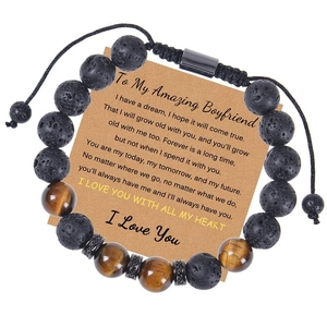 Macro shot of 10mm tiger eye and lava stone beaded bracelet on a warm gift card