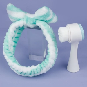 Mint green silicone face cleansing brush set with a soft bow headband on purple background