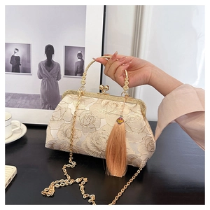 Detail of beige Chinese peony embroidery shell bag with gold handle and tassel accent