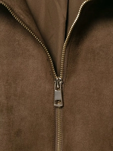 Detailed macro shot of metal zipper on dark brown faux suede bomber jacket