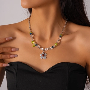 Détail du collier de perles en verre avec pendentif fleur en argent et pierre rouge