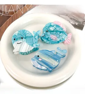 Detailed close-up of blue ocean-themed dolphin hair claw made of marbled acetate with pearls