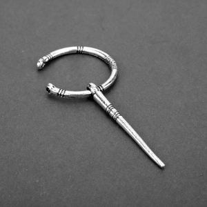Detailed view of silver Viking brooch with retro striped patterns and pin fastener