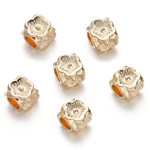 Detailed view of six golden floral spacer beads with sunflower patterns for DIY jewelry